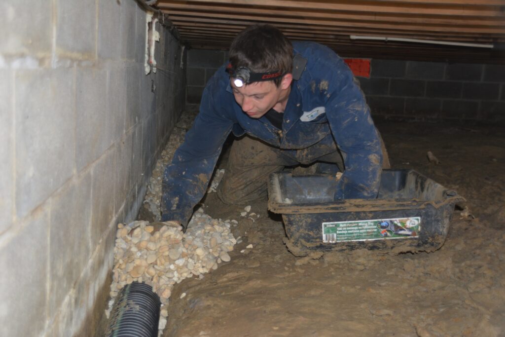 Person working in a crawl space.